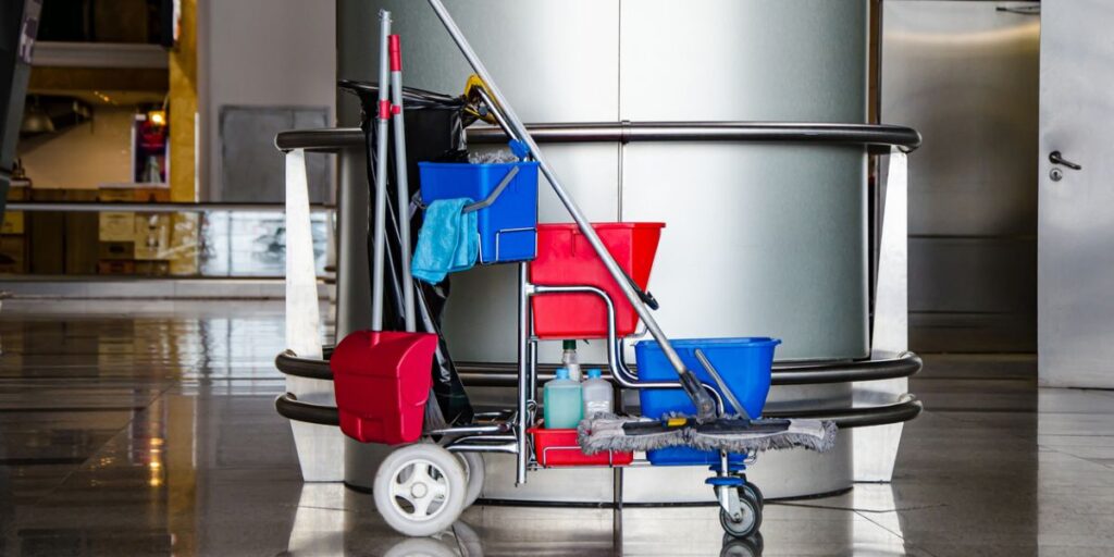 A cart full of cleaning supplies in a lobby for commercial cleaning services