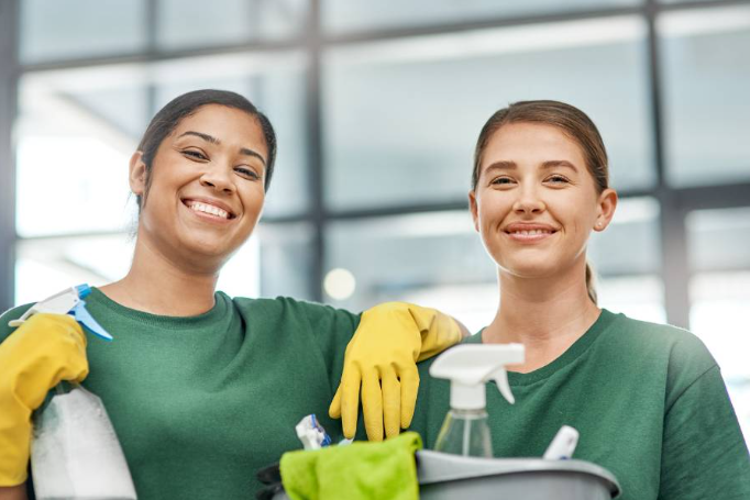 Two female AK Building Services employees finishing up an office clean.