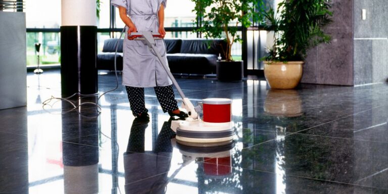 A professional commercial cleaner perfects showroom cleaning by steaming and waxing the floors.